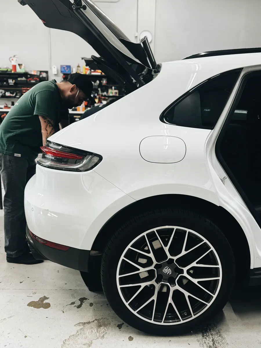FRQNCY technician installing a subwoofer and amplifier in a Porsche Macan trunk