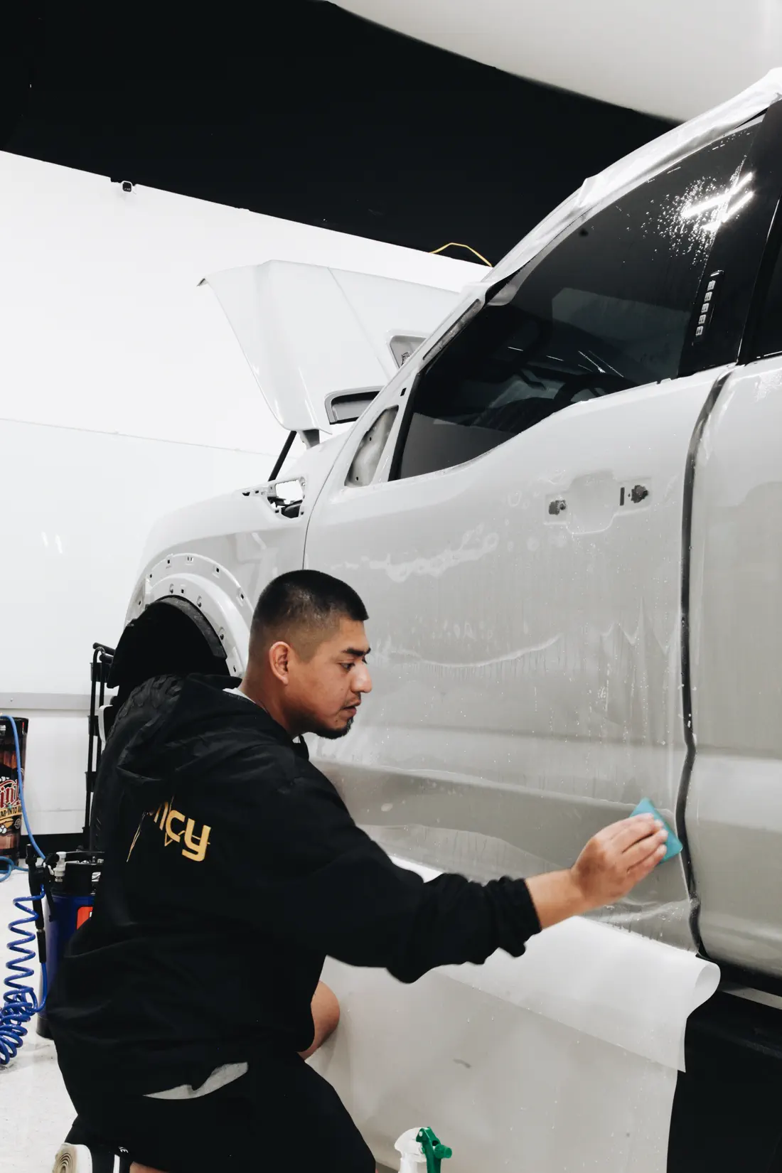 FRQNCY technician installing window film in a filtered bay